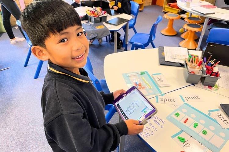 a student using an iPad to take a photo of their work.