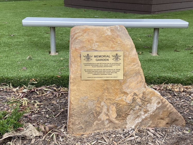 a close up view of the rock with the plague on it in the ANZAC garden.