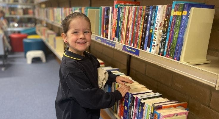 a student looking through some books in the library.